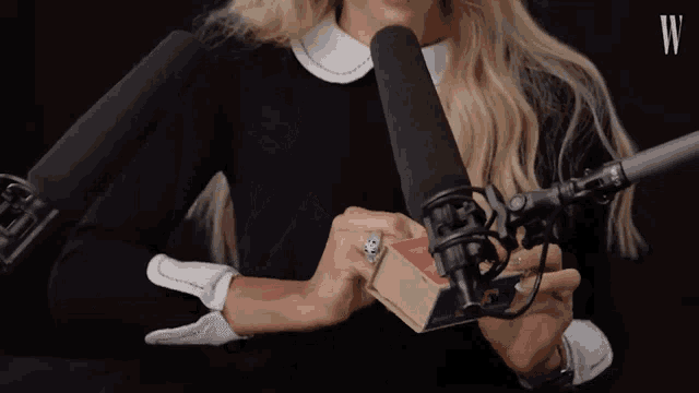 a woman lighting a match in front of a microphone