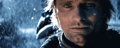 a close up of a man 's face with snow falling around him
