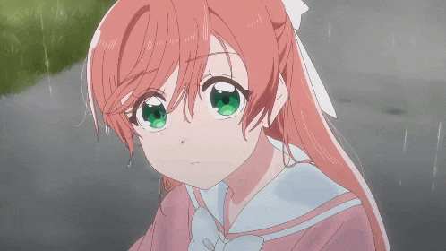 a girl with red hair and green eyes is wearing a pink shirt