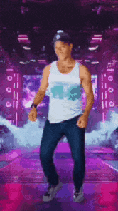 a man in a tank top and hat is dancing on a stage