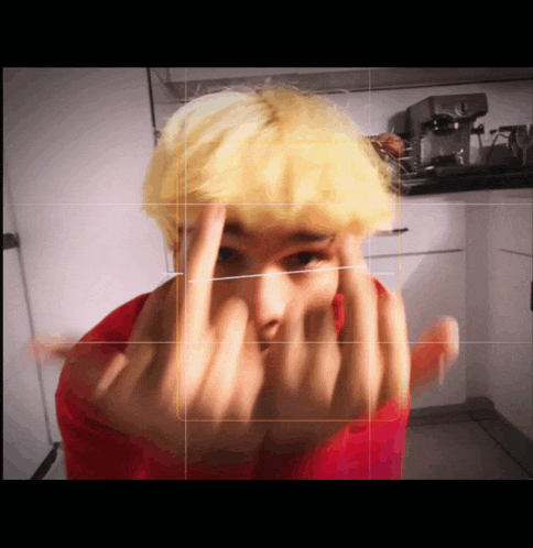 a man with yellow hair is making a middle finger sign