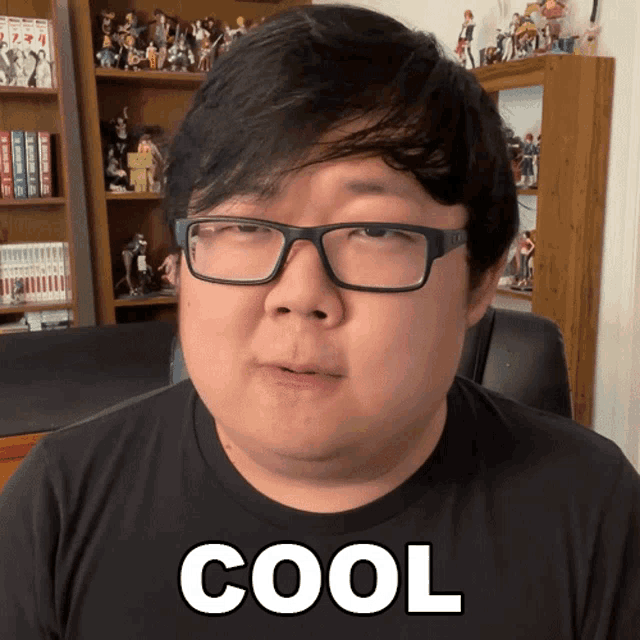 a man wearing glasses and a black shirt has the word cool on his shirt