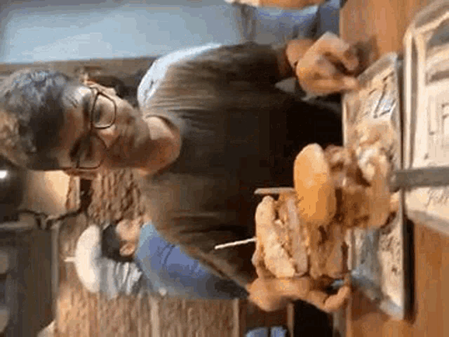 a man is eating a hamburger with a knife and fork .