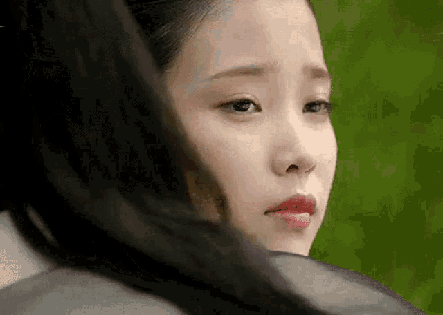 a close up of a woman 's face with a person 's hair behind her .