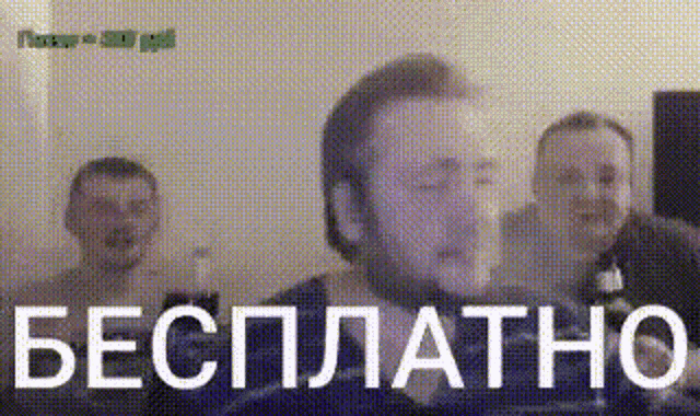 a man with a beard stands in front of a sign that says бесплатно