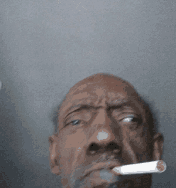 a man with a cigarette in his mouth looks angry