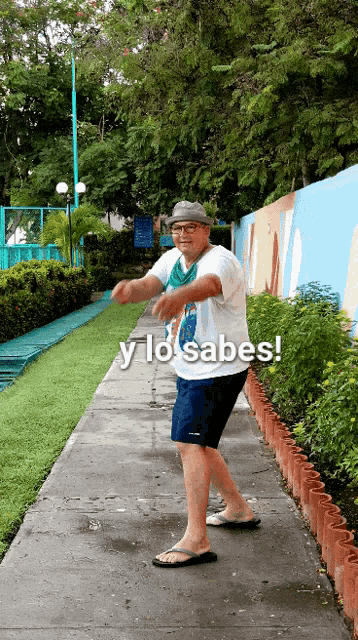 a man is dancing on a sidewalk with the words y lo sabes written above him