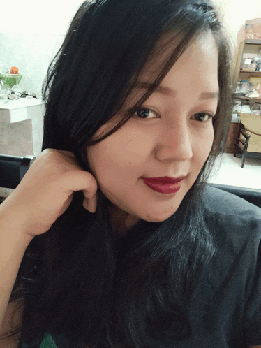 a woman with long black hair and red lipstick