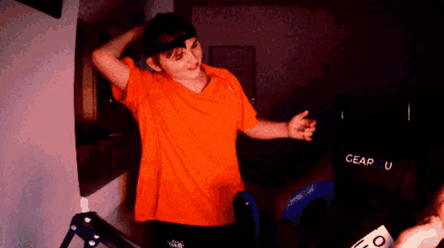 a person in an orange shirt is standing in front of a chair that says gear u