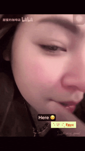 a close up of a woman 's face with a sticker that says here on it