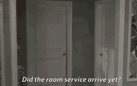 a woman is standing in a doorway with the words `` did the room service arrive yet ? '' written on it .