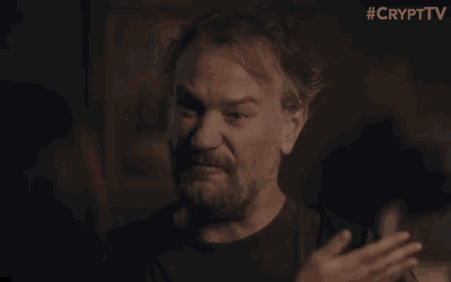 a close up of a man covering his mouth with his hand