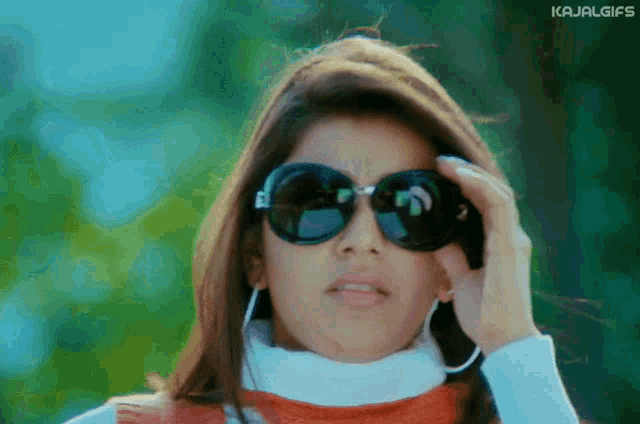 a woman wearing sunglasses has the word kajal gifs on the bottom of her face
