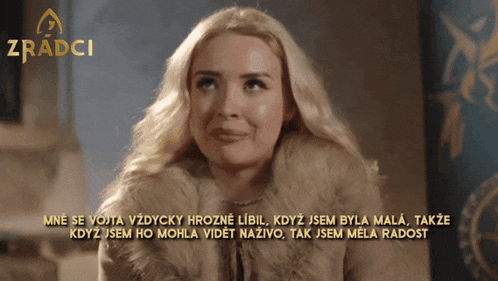 a woman in a fur coat is smiling in front of a zradci logo