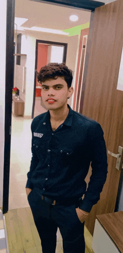 a young man wearing a black shirt with the word liberty on it stands in a doorway