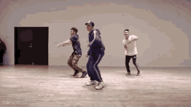a group of young men are dancing in a dance studio with the word dance on the bottom