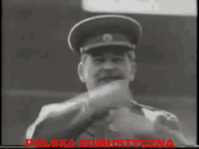 a black and white photo of a man with the words polska komustyczna written in red