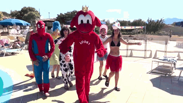a group of people dressed in costumes including a mascot that says looky