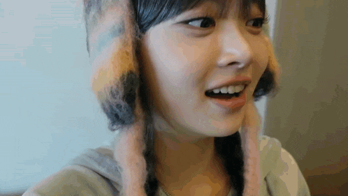 a close up of a woman wearing a furry hat with ears .