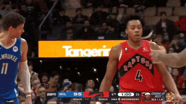 a basketball player wearing a red raptors jersey stands next to another player