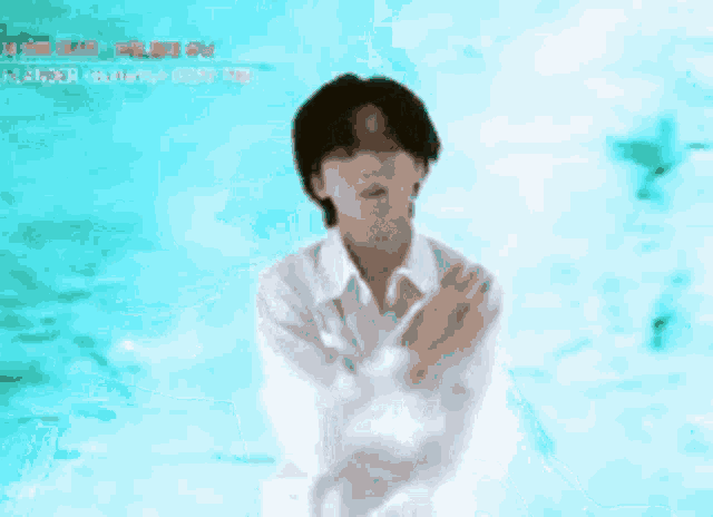 a man in a white shirt is holding a microphone in front of a blue background .