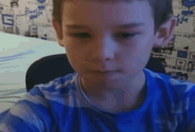 a young boy wearing a blue and white striped shirt