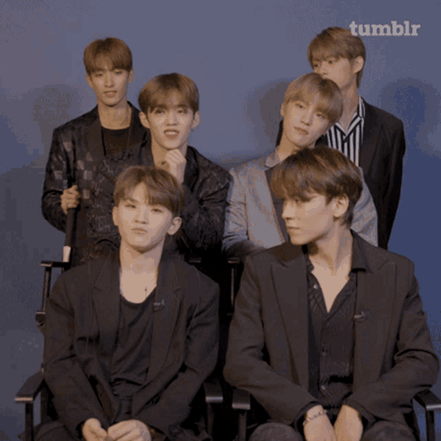 a group of young men sitting in front of a blue background with tumblr written on the bottom