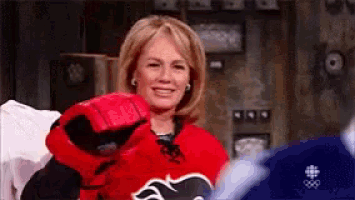 a woman is wearing a red hockey jersey with a bear on it