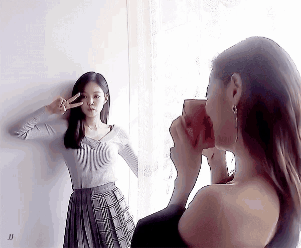 a woman taking a picture of another woman with a coca cola cup in her hand