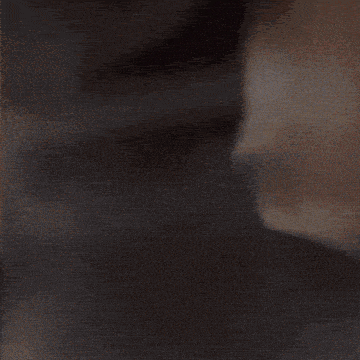 a close up of a person 's face with a shadow on the wall
