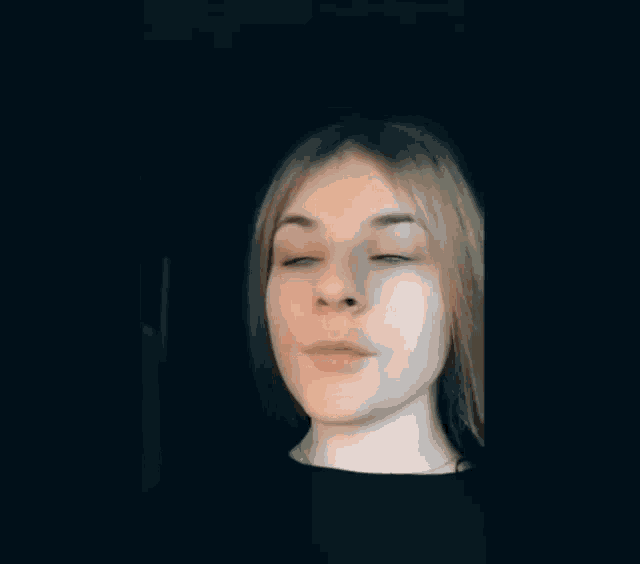a close up of a person 's face with a black background .