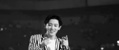 a black and white photo of a man with his arms outstretched in a striped jacket .