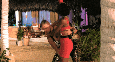 a man in a red dress is holding a woman in a red dress
