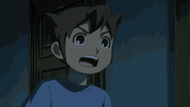 a boy in a blue shirt stands in a dark room