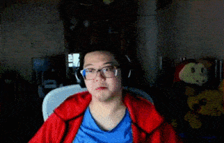 a man wearing glasses and headphones is sitting in front of a stuffed animal