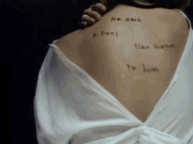 a woman 's back has a tattoo that says he said i feel like home to him
