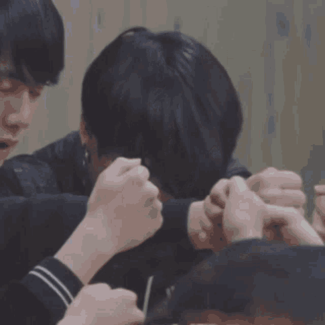 a group of people are holding each other 's hands and one of them has korean writing on his face