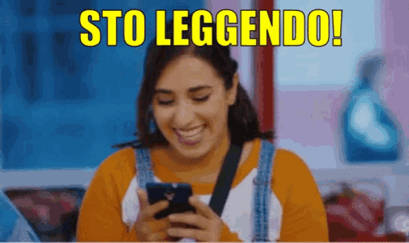 a woman is smiling while looking at her cell phone and the words sto leggendo are above her