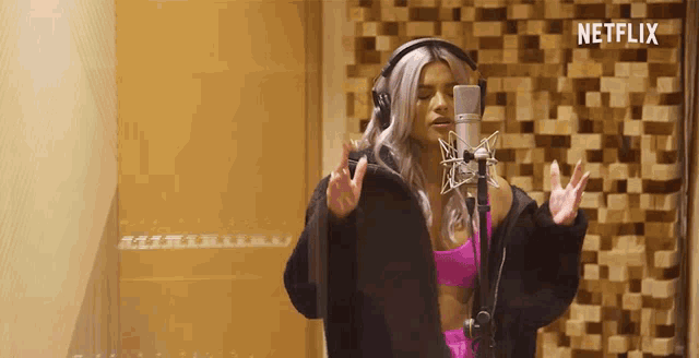 a woman singing into a microphone with netflix written on the bottom right