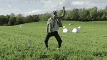 a man is dancing in a field with hay bales .