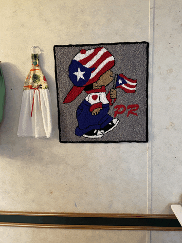 a towel hanging on a wall next to a picture of a boy holding a flag that says pp