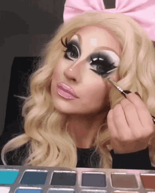 a woman wearing a pink bow is applying makeup