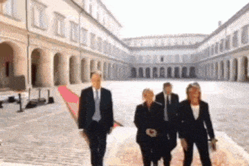 a group of people walking in front of a large building