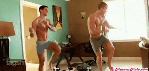 two shirtless men are dancing in a room with the website marcusmojo.com