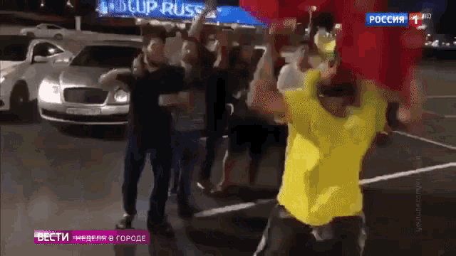 a group of people are dancing in front of a sign that says cup russia