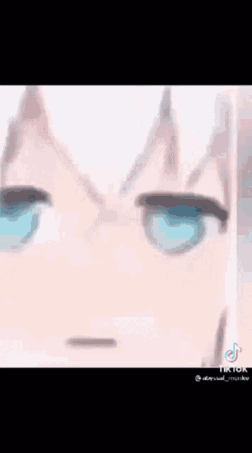 a close up of a anime character 's face with blue eyes making a funny face .