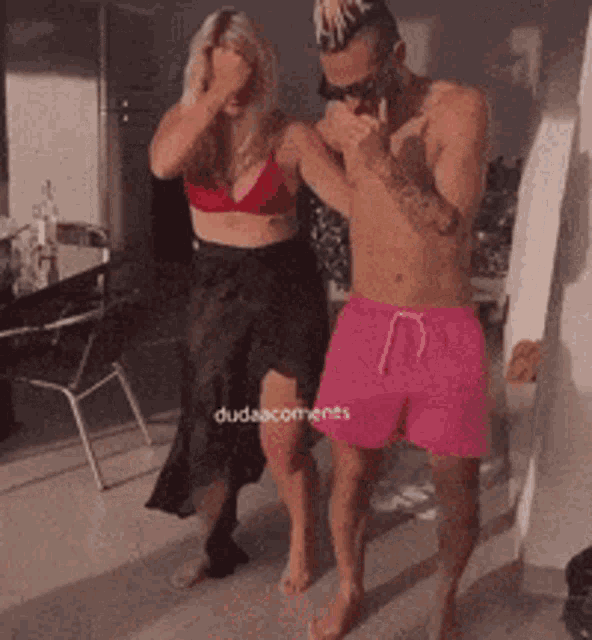 a man and woman are standing next to each other in a room .
