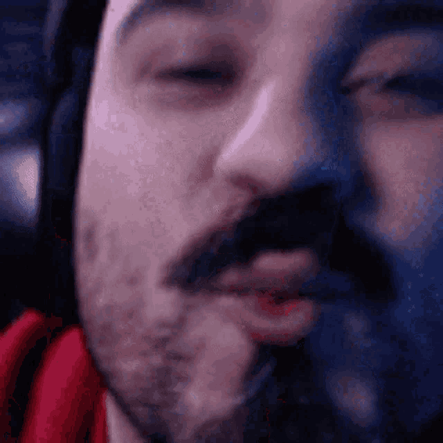 a close up of a man 's face with his eyes closed and a beard