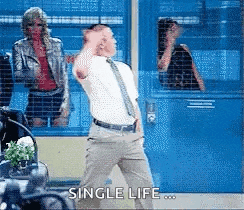 a man in a suit and tie is dancing in front of a blue door with the words single life written on it .