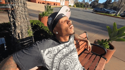 a man sitting on a park bench with his eyes closed